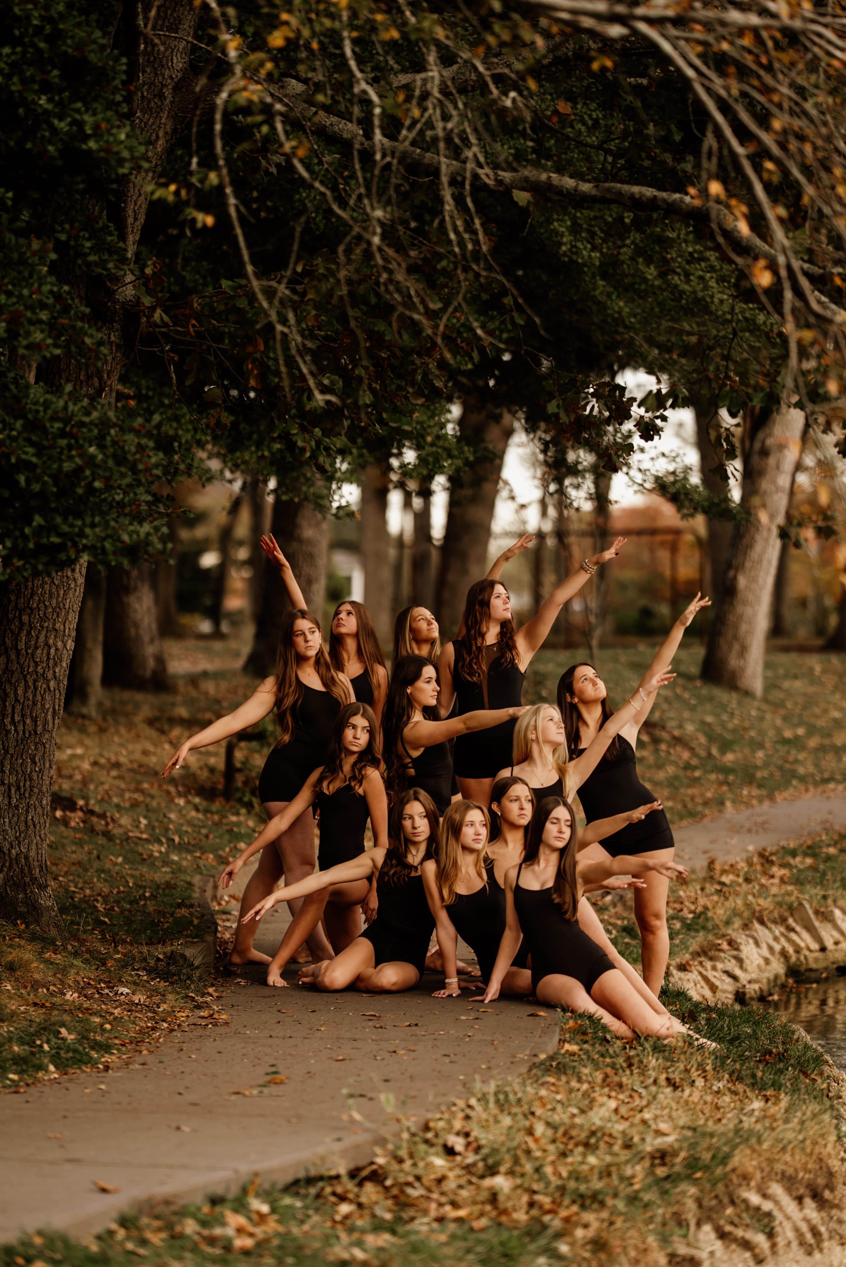 Company dancers striking dynamic jazz poses together outdoors